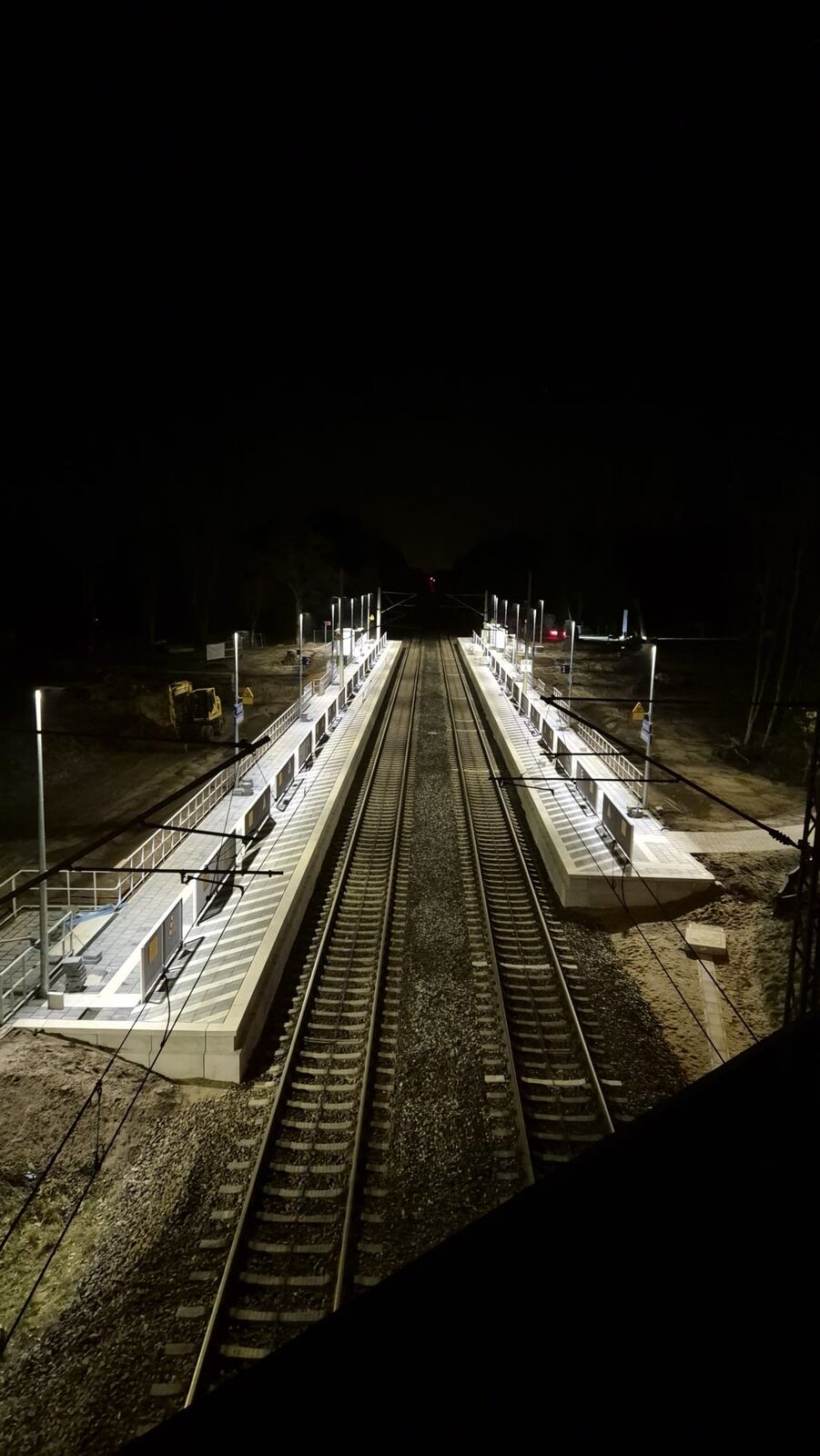 Beleuchteter Mittelbahnsteig bei Nacht, Bahnsteigbeleuchtung in Betrieb