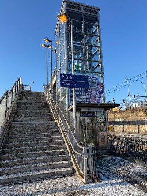 Treppen- und Aufzugszugang zum Mittelbahnsteig mit Leuchten
